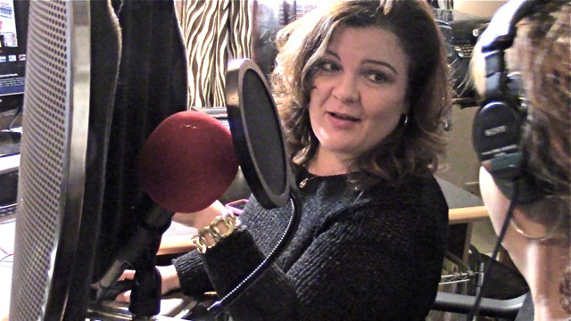 Dina Tulli Davis, in front of podcast mic