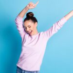 Woman with arms in air and look of accomplishment and celebration on her face