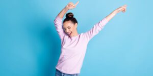 Woman with arms in air and look of accomplishment and celebration on her face